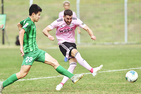 ◎ 二月十二日,愉園隊球員加維蘭(右)在比賽中射門。在賽馬會香港足球總會足球訓練中心舉行的香港菁英杯足球賽B組比賽中,和富大埔隊以四比四戰平愉園隊。(新華社 盧炳輝 攝)