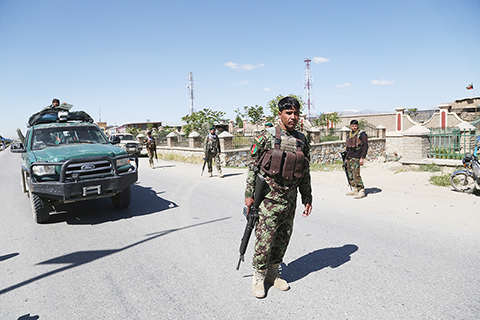警戒 ◎ 五月十八日,在阿富汗東部加茲尼省首府加茲尼市,安全人員在發生汽車炸彈爆炸的地點附近警戒。(新華社)