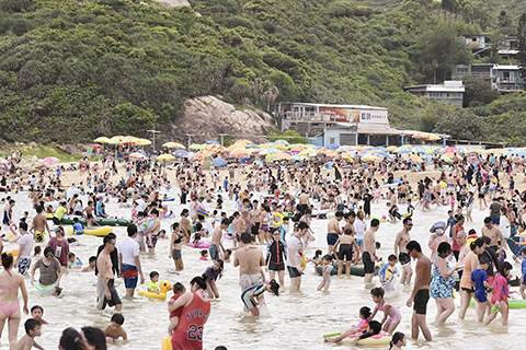 ◎ 大批市民昨日到石澳泳灘玩耍,人頭湧湧。端午節當天,氣溫高達三十二度。大批市民到香港各個泳灘游龍舟水,樂也融融。(香港中通社記者 舒書 攝)
