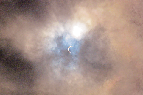 ◎ 雲隙中的日偏食食甚。