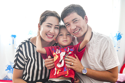 ◎ 7月20日,阿拉帕提·牙森(右)與妻子古麗斯坦·艾山、兒子帕合爾丁·阿拉帕提在家中合影。