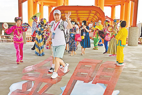 再現人潮 ◎ 全球首艘復航郵輪「星夢郵輪─探索夢號」島內跳島遊上周五搭載一千零廿二人到金門,縣府以傳統藝陣迎接來自海上的遊客,紅男綠女穿梭各地景點,也為二月十日起因疫情停航的「小三通」碼頭,再帶來人潮湧現的熱鬧氣氛。