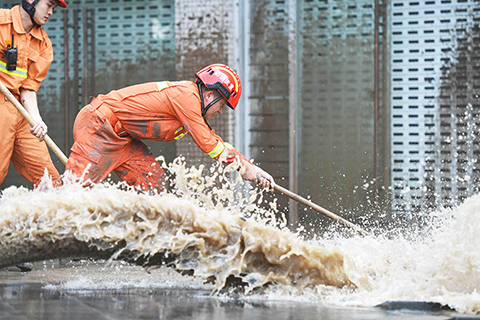 ◎ 八月二十一日,重慶南岸消防救援支隊的消防員正在進行清淤工作。當日,長江水勢回落,重慶南濱路被淹路段開展清淤工作。(中新社)