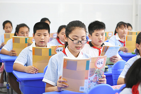 ◎ 八月三十一日,在安徽省肥西縣花崗學區中心學校新校區,學生們在教室內朗讀課文。當日,在做好疫情防控工作的前提下,安徽各區縣(市)的普通中小學正式迎來開學季。(中新社)