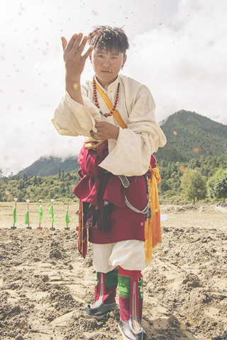 ◎ 西藏林芝市米林縣裡龍鄉德吉新村村民多吉久美向一片新的試驗田播撒牧草種子(九月十三日攝)。(新華社記者 孫非 攝)