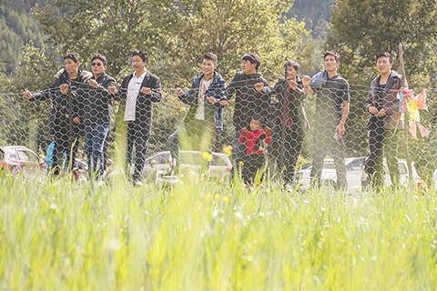 ◎ 西藏林芝市米林縣裡龍鄉德吉新村村民圍在人工草場周圍查看飼草長勢(九月十三日攝)。(新華社記者 孫非 攝)