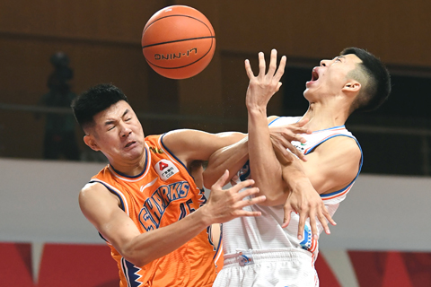 ◎ 十月二十七日,上海久事隊球員何重達(左)與福建豹發力隊球員李英博在比賽中拼搶。(新華社 沙達提 攝)