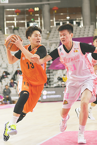 ◎ 十二月一日,內蒙古農信隊球員張琦芳(左)在比賽中帶球突破北京首鋼隊劉超凡的防守。(新華社 劉磊 攝)