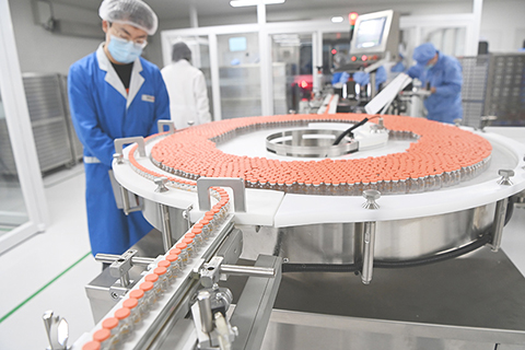 ◎ 一月六日,中國新聞社記者前往位於北京市大興區的北京科興中維生物技術有限公司,探訪新型冠狀病毒滅活疫苗生產線。圖為工作人員在生產線上檢查西林瓶裝疫苗。(中新社)