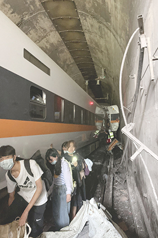 ◎ 台鐵「太魯閣號」,圖為乘客離開事故現場。(香港中通社)