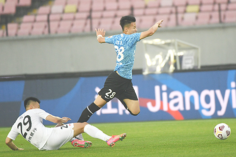 ◎ 四月二十二日,大連隊球員林良銘(右)在比賽中帶球突破。最終長春亞泰隊以二比一戰勝大連人隊。(新華社發 史康攝)