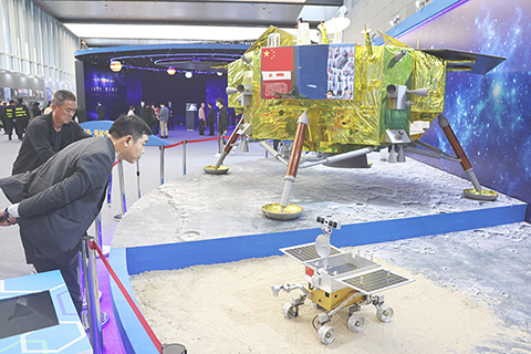 ◎ 四月二十四日,「揚帆起航逐夢九天」中國航天日科普宣傳周暨「航天放飛中國夢」科普巡展活動在江蘇省南京市開展。科普區域展出了重大航天工程航天器模型、實物展品等。月球樣品實物及嫦娥五號返回艙、降落傘等實物首次在京外展出。圖為參觀者被展出的嫦娥三號和月球車模型吸引。(中新社)