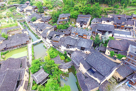 ◎ 漫步於福建寧德市屏南縣熙嶺鄉龍潭村,穿村而過的溪流兩側,是一座座黃牆黛瓦、錯落有致的古樸老宅。溪邊,孩童嬉戲、婦人浣衣;石板路上、亭子內,可見一些畫家前來寫生、作畫。圖為五月十三日,航拍龍潭古村落。(無人機照片)(中新社)