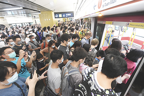 ◎ 六月二十七日,港鐵屯馬線於早上五時五十分正式全線通車,逾百鐵路迷於宋皇台站登上頭班車。(中新社記者 李志華 攝)