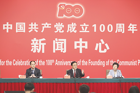 ◎ 六月二十七日,慶祝中國共產黨成立一百周年活動新聞中心在北京舉行第一場新聞發佈會,介紹新時代黨史和文獻工作。圖為中央黨史和文獻研究院院長曲青山(中)回答記者提問。(中新社)