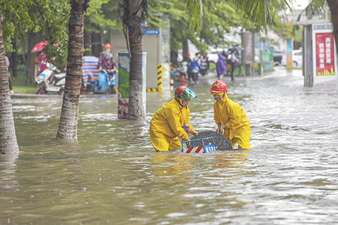 ◎ 七月六日,海口市水務局的工作人員在積水路段進行排水作業。受南海熱帶低壓影響,海南省海口市迎來強降雨天氣,市區多條路段出現積水。海口市氣象台當日發佈暴雨紅色預警信號。(中新社)