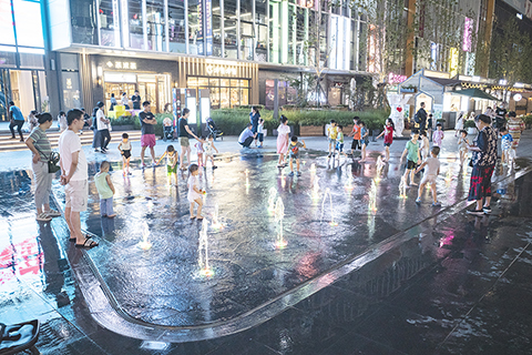 ◎ 七月二十日,《中共中央國務院關於優化生育政策促進人口長期均衡發展的決定》公佈。《決定》明確,取銷社會撫養費,清理和廢止相關處罰規定,將入戶、入學、入職等與個人生育情況全面脫鈎。圖為七月二十日晚間,少年兒童在家長的陪伴下在北京市朝陽區望京小街的噴泉處玩耍。(中新社)