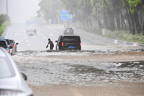 ◎ 七月二十日,受今年第七號台風「查帕卡」影響,深圳遭遇強降雨,氣象台已發佈台風藍色預警信號。該市區低窪路面出現積水、車輛遇阻。圖為新洲路與深南大道立交橋下的積水場景。(中新社)