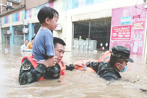 ◎ 八月十二日,隨州市何店鎮,武警官兵將一名小朋友扛在肩上轉移到安全地帶。八月十一日至十二日早上,湖北省隨州市遭遇強降雨襲擊,局部出現特大暴雨。(中新社)