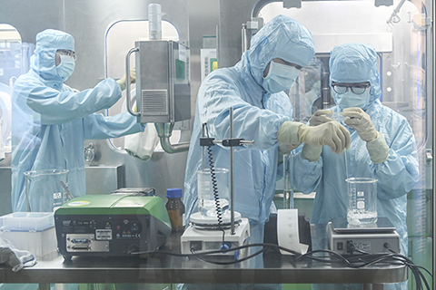 ◎ 圖為十一月八日,廣東省廣州市,聖諾生物醫藥技術(廣州)有限公司的工作人員在無菌空間內進行相關實驗。(中新社)