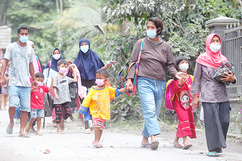 　◎ 十二月五日，在印度尼西亞東爪哇省盧馬姜，人們準備乘車撤往臨時避難所。印度尼西亞國家抗災署五日說，印尼東爪哇省塞梅魯火山噴發已造成十三人死亡。（新華社）