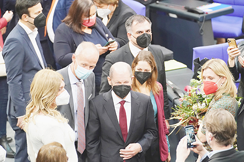 　◎ 圖為十二月八日，朔爾茨（中間穿紅領帶）當選後，不同政黨的議員向其獻花和道賀。（香港中通社）