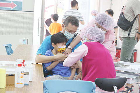 　◎ 五月二十七日，家長帶孩子接種疫苗。台灣接連發生兒童新冠確診後併發腦炎死亡案例，目前重症已累計十八例，八例死亡，不少家長擔心，竭盡所能地替孩子搶約兒童疫苗，不少地方一針難求。（香港中通社圖片）