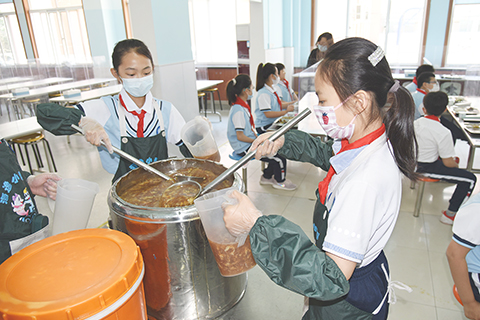 ◎ 青島海逸學校的「小幫廚」在餐廳為同學提供服務。