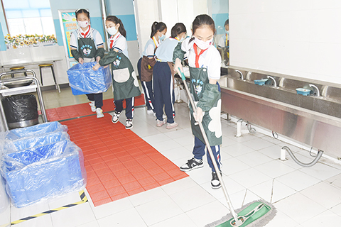 ◎ 青島海逸學校的「小幫廚」在同學們用餐後打掃餐廳。