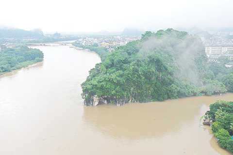 ◎ 六月五日,受持續強降雨影響,廣西桂林漓江水位迅漲。根據桂林水文中心信息,當日二時三十分,漓江桂林水文站出現一百四十六點一零米洪峰水位,超過警戒水位零點一零米,流量為二千四百七十立方米每秒。這是入汛以來漓江首次出現超警洪水。圖為廣西桂林市城區漓江段象鼻山水域。(無人機照片)(中新社)