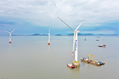 這是2021年5月28日拍攝的華電福清海壇海峽海上風電項目首台海上風電主控系統國產化機組(右)(無人機照片)。 (新華社記者 姜克紅攝)