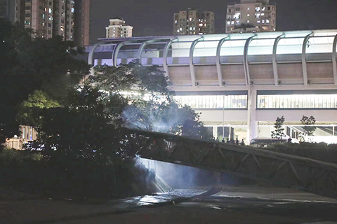 ◎ 六月二十一日晚,香港元朗宏達路近朗屏港鐵站附近,有電力公司的設施起火,整條搭載電纜天橋陷入火海,從遠觀望天橋內火光熊熊。(香港中通社記者 張海德 攝)