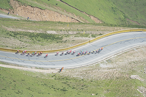 ◎ 七月二十八日,環湖賽車手們在青海省海南藏族自治州貴德縣拉脊山盤山公路上爬坡。(中新社記者 馬銘言 攝)