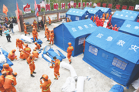 ◎ 九月七日,救援人員在磨崗嶺村搭建帳篷。當日,甘孜州森林消防支隊七十名消防員運送二十八頂救災帳篷至四川甘孜藏族自治州瀘定縣磨西鎮磨崗嶺村。受地震影響,磨崗嶺村通往外界唯一的道路中斷,救援人員通過徒步方式、翻山越嶺運送帳篷,村民也在途中利用騾馬、摩托車等接力傳遞救災物資。(中新社)