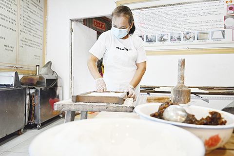 圖為7月6日,黃智英在製作雲片糕。(中新社發 侯芸瑩)