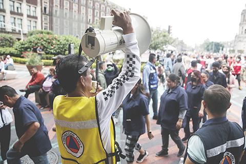 ◎ 墨西哥國家地震局九月十九日稱,該國西部米卻肯州當天下午發生七點七級地震。墨西哥總統洛佩斯稱,地震已造成一人死亡。墨西哥首都墨西哥城當天震感強烈。圖為當日,在墨西哥首都墨西哥城,民防人員引導室外避險的民眾。(新華社)