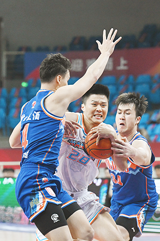 ◎ 十月二十三日,山東高速隊球員劉冠岑(中)在新疆伊力王酒隊球員伊力福拉提(左)、艾孜麥提的防守下進攻。山東高速隊以一百零五比九十二戰勝新疆伊力王酒隊。(新華社記者 陳振海 攝)