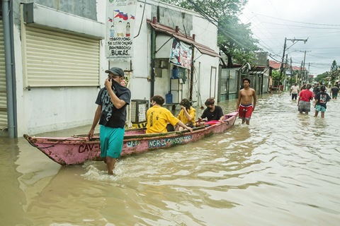 ◎ 十月三十日,人們在菲律賓甲米地省被洪水淹沒的街道上前行。受熱帶風暴「尼格」影響,菲律賓多地遭遇暴雨,部份城市積水嚴重。(新華社發 烏馬利 攝)