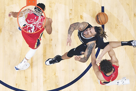 ◎ 鵜鶘三號麥高林和丹尼爾斯(右)力阻灰熊奇勒上籃。(美聯社)