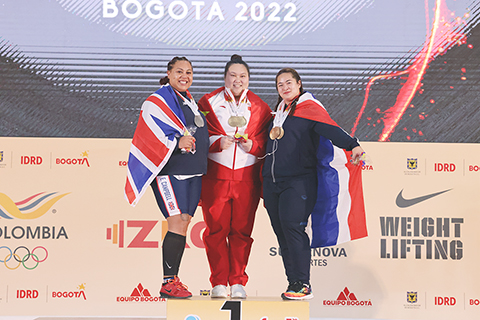 ◎ 十二月十五日,中國選手李雯雯(中)與英國選手坎貝爾·艾米麗·傑德(左)和泰國選手柴迪.杜安卡松在頒獎儀式上合影。李雯雯奪得抓舉、挺舉項目和總成績三枚金牌。(新華社發 唐薇 攝)