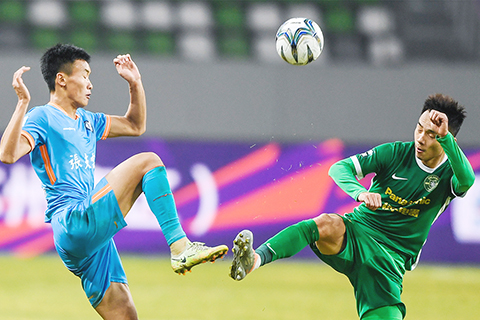 ◎ 一月五日,濟南興洲隊球員孫恩明(左)與浙江隊球員顧斌在比賽中拼搶。在江蘇蘇州舉行的中國足協盃四分之一決賽首回合比賽中,浙江隊以三比0戰勝濟南興洲隊。(新華社記者 李博 攝)