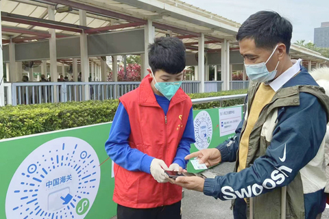 ◎ 志願者在輔助旅客作電子申報。(申龍華攝)