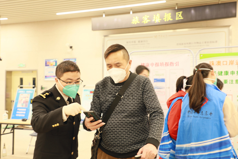 ◎ 青茂海關關員在指導旅客填寫健康申報信息。(劉曉萍攝)