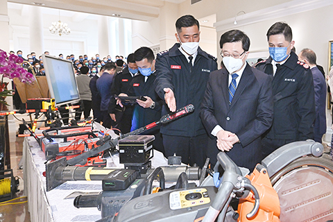 ◎ 二月二十日,香港特區行政長官李家超在禮賓府宴請香港特別行政區救援隊。圖為李家超(右二)在消防處處長楊恩健(右一)陪同下,聽取銷防處代表講解在土耳其地震災區搜救工作中使用的工具。(香港中通社)