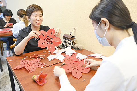 ◎ 三月十六日,廣東省廣州市,市民製作以木棉花為主題的剪紙作品。當日,廣州高劍父紀念館舉辦「藝剪紅棉──非遺手工剪紙」活動,吸引市民前來體驗。(中新社記者 陳驥旻 攝)