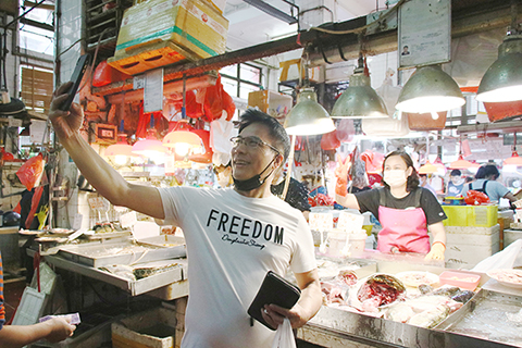 街坊與檔主隔著檔位自拍。