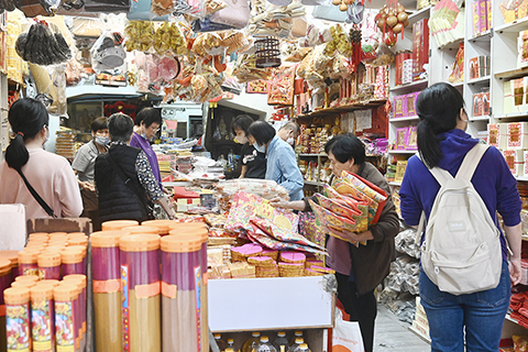 ◎ 四月四日,清明節前夕,香港市民到紙紮舖選購祭品,商家一早準備好大量香燭、紙紮祭品等供市民選購。圖為市民選購香燭等祭品。(中新社記者 李志華 攝)