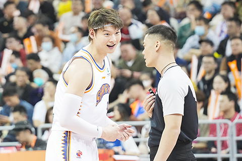 ◎ 四月九日,上海久事隊球員王哲林(左)在比賽中與裁判交流。在CBA季後賽首輪比賽中,上海久事隊主場以一百一十九比九十五戰勝蘇州肯帝亞隊,總比分一比0領先。(新華社記者 丁汀 攝)