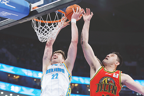 ◎ 四月十日,北京首鋼隊利夫(左)在比賽中扣籃。在北京進行的CBA季後賽第一輪比賽中,北京首鋼隊主場以一百二十三比七十九戰勝九台農商銀行隊。(中新社記者 韓海丹 攝)