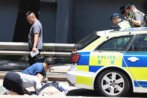◎ 六月十日,香港一可疑私家車拒絕執法人員截查,在何文田公主道近紅磡警署時企圖撞開前來截停的警車,其後撞向護欄,最終警方鳴槍將涉事司機逮捕,事件中無人受傷,涉事車輛左邊車窗破裂,車頭損壞。圖為警方在現場尋找彈頭。(香港中通社記者 許其皓 攝)